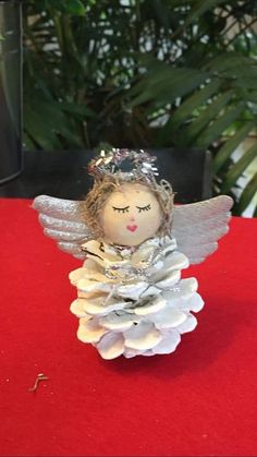 an angel figurine sitting on top of a red table