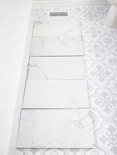 a bathroom with white and gray tile on the floor