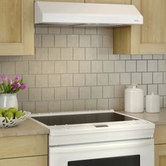 a white stove top oven sitting inside of a kitchen next to wooden cabinets and counter tops