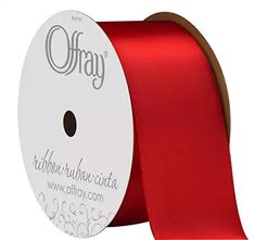 a roll of red satin ribbon with the word on it in white lettering and an orange spool