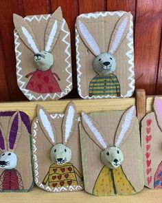 four little bunny magnets are sitting on a shelf next to some wood planks