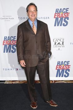 a man in a suit and tie standing on a black carpeted area with the words race erase mss