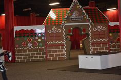 a child is walking past a gingerbread house on display at the children's museum