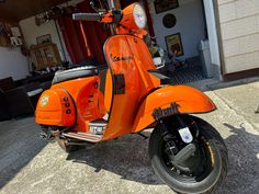 an orange scooter parked in front of a building