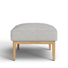 the foot stool is made from wood and has a light gray upholstered fabric