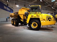 a large yellow dump truck parked inside of a building