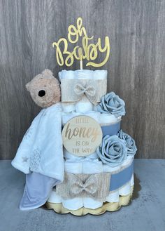 a teddy bear sitting on top of a diaper cake