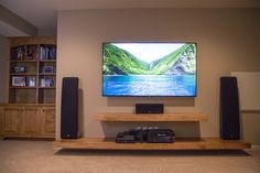 a flat screen tv sitting on top of a wooden shelf in front of a wall