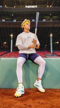 a man sitting on a bench holding a baseball bat