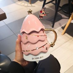 a pink ice cream sundae shaped mug with gold stars on it's rim