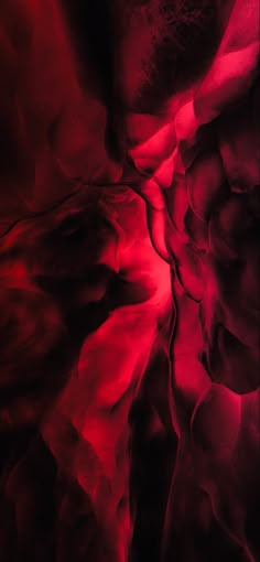 an abstract red and black background with some sort of substance in the foreground that appears to be liquid