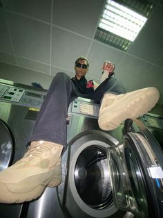 a man sitting on top of a washing machine