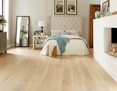 a bedroom with white walls and wood floors