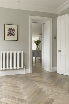 an empty room with a radiator and wooden floors