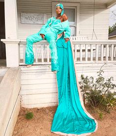 a woman in a blue dress sitting on a porch