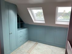 an empty room with skylights and blue cabinets