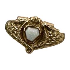 This is a museum quality antique Egyptian Revival Opal Snake Phoenix Bird Ring. The antique ring has a central hexagonal Opal cabochon of great beauty. The Opal is set in 10 Karat Gold. The opal is framed by two entwined snakes or stunning renditions of a winged Phoenix bird. The gold is a beautiful warm yellow 10 Karat Gold. It is very rare to find opals in the early antique Egyptian Revival jewels, and the combination with the snakes is extraordinary. The ring dates to circa 1860-1920. For centuries, Ancient Egypt has held the fascination of the public and continues to inspire artists and designers alike. With the discoveries of Egyptian tombs, and the treasures within, in the 19th and early 20th centuries, the exotically opulent lives of the Pharaohs were beyond anyone’s imagination. Of Egyptian Revival Jewelry, Bird Ring, Bird Rings, Phoenix Bird, Egyptian Revival, Warm Yellow, Jewelry Accessories Ideas, Antique Ring, Art Deco Era