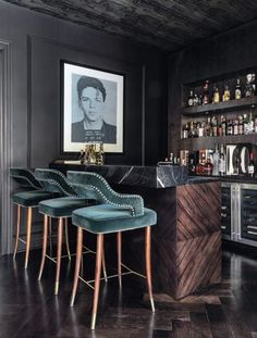 a bar with stools and bottles on the shelves