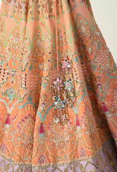 The husnsah lehenga set is a bright and beautiful attire in lavender and peach. The lehenga is vivid with geometric & floral embroidery and multicolored sequin mixed with mirrorwork while the blouse features intricate details and an off shoulder v neckline.The lehenga is a perfect festive wear that brings glamour even with minimal accessories and makeup. Peach Anarkali With Mirror Work, Peach Traditional Wear With Intricate Embroidery For Reception, Orange Mirror Work Dupatta For Reception, Festive Peach Anarkali Set With Intricate Embroidery, Multicolor Lehenga With Dabka Work For Reception, Peach Sharara With Dabka Work For Weddings, Multicolor Dabka Work Lehenga For Reception, Designer Embroidered Peach Sharara, Designer Wear Embroidered Peach Sharara