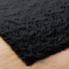 black shaggy rug on wooden floor with hard wood flooring