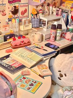 a desk with many items on it and a teddy bear sitting next to the table