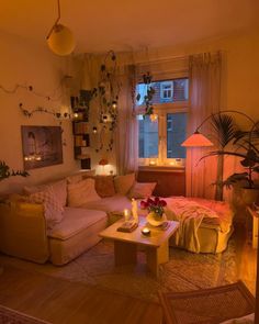 a living room filled with lots of furniture next to a large window covered in plants