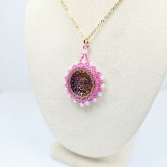 Add a touch of elegance and charm to your outfit with this beautiful handmade beadwork glass pendant!  Hand woven pendant features a stunning Czech pressed glass rosette cabochon surrounded by intricate beadwork featuring fine Miyuki glass seed beads and sparkling crystal rondelle beads. The pendant hangs delicately from a Gold-plated Stainless Steel chain. Whether you're dressing up for a special occasion or simply adding a pop of color to your everyday look, this pendant is sure to turn heads and spark joy wherever you go!  Each piece is lovingly crafted by hand, making it a unique and special addition to your jewelry collection. Treat yourself or surprise a loved one with this one-of-a-kind piece that is sure to gather compliments! 👉  Hand beaded by CyntheCreations 👉  Measurements:  1 Adjustable Beaded Necklace With Teardrop Pendant, Gift Pendant Beaded Necklace With Tiny Beads, Elegant Beaded Necklace With Flower Pendant, Handmade Adjustable Beaded Necklace With Teardrop Pendant, Handmade Adjustable Teardrop Pendant Beaded Necklace, Handmade Adjustable Teardrop Pendant Beaded Necklaces, Beaded Czech Glass Pendant Necklace, Beaded Czech Glass Cabochons For Jewelry Making, Beaded Czech Glass For Jewelry Making