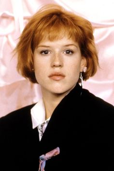 a woman with red hair wearing a black jacket