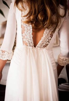 the back of a woman's white dress with lace detailing