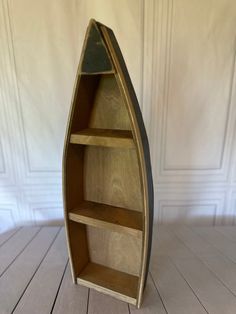 Wooden three shelf boat unit. Stained natural wood accents with a black distressed exterior base. Measures 24”H x 8”W x 3”D Canoe Shelf, Boat Shelf, Natural Wood Accents, Nursery Room Inspiration, Wood Boats, Fish Market, Shelf Unit, Entertainment Room, Wood Accents