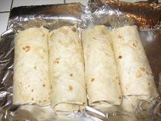 four tortillas wrapped in aluminum foil on the counter