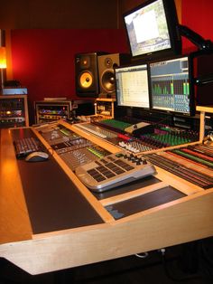 the control room of a recording studio with multiple monitors and sound mixing equipment on it