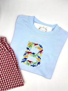 Boys Dinosaur Blue T Shirt with Embroidery Colors customizable. Sizes 18 mo to 8. Shorts sold separately. Listing includes name or monogram Nice, thicker cotton boutique quality t shirts Let me know if you want white shirt or Long Sleeve! If you don't see a size here that you need, I will be glad to check to see if I have it. Please convo me for questions. Blue Dinosaur Print Long Sleeve Top, Blue Long Sleeve Dinosaur Print Top, Long Sleeve Blue Top With Dinosaur Print, Blue Long Sleeve Top With Dinosaur Print, Blue Dinosaur Print Top For Playtime, Crew Neck Top With Dinosaur Print For Playtime, Short Sleeve Dinosaur Print Tops For Playwear, Spring Playtime Tops With Dinosaur Print, Cute Dinosaur Print Tops For Playwear