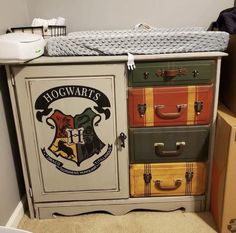 a harry potter dresser with many different suitcases on it's drawers and the hogwarts crest painted on top