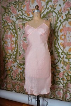 A lovely pale pink slip. Luxe, silk-like rayon typical to loungewear of the era. This garment does not have any stretch, but the bias cut does offer a bit of wiggle room. Size XS. 33" chest, up to 27" waist, up to 34" hips, 34.5" long. 100% rayon. Made in the USA. 1940's-50's Pink Silk Slip Dress With Bias Cut, Fitted Bias Cut Slip Dress For Sleep, Pink Silk V-neck Slip Dress, Pink Silk Feminine Slip Dress, Pink Silk Slip Dress For Daywear, Vintage Pink Slip Dress For Daywear, Pink Fitted Silk Slip Dress, Fitted Silk Slip Dress In Pink, Feminine Fitted Slip Dress For Loungewear