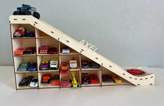 a toy car display case with cars in it and on the bottom shelf is a ladder