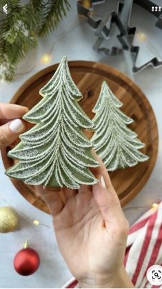 someone is decorating a small christmas tree cookie