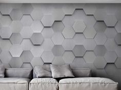 a couch sitting in front of a wall with hexagonal tiles on it