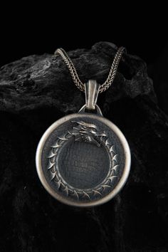 This Ouroboros dragon snake ring necklace is stylish and pretty ideal for everyday use. The engraving details of the 925k handmade silver pendant are very detailed and eye-catching. The jewelry is coated with oxide to emphasize the details of handmade engraving The best colors are Oxidized-Rose-Yellow and Rhodium Color on this product you can see all details clearly. You can find Product colors variations shown as representative on  image. Made from high-quality sterling silver, this ouroboros n Sterling Silver Necklace With Dragon Design, Engraved Metal Snake-shaped Jewelry, Dragon Design Metal Jewelry, Round Metal Jewelry With Dragon Design, Sterling Silver Jewelry With Dragon Design Round Pendant, Silver Dragon Design Round Pendant Jewelry, Silver Dragon Design Collectible Jewelry, Silver Snake-shaped Oxidized Jewelry, Oxidized Silver Snake Jewelry