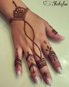 a woman's hand with henna tattoos on it