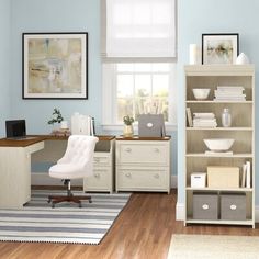 a white chair sitting in front of a book shelf next to a desk with a computer on it