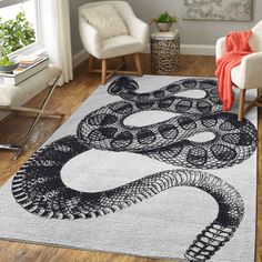 a large rug with a snake on it in a living room next to two chairs