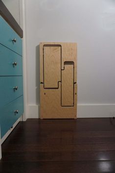 a wooden cabinet sitting on top of a hard wood floor next to a blue dresser