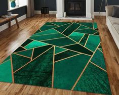 a green area rug with gold lines on it in front of a couch and fireplace