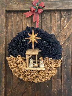 a nativity wreath hanging on the side of a barn door