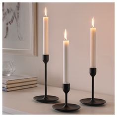 three lit candles sitting on top of a table