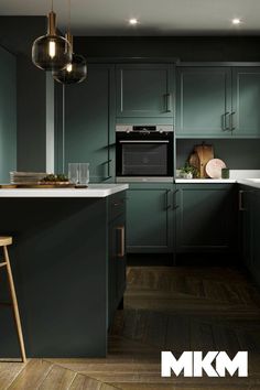 an image of a kitchen with green cabinets and white counter tops in the center area