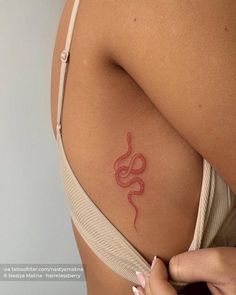 a woman's stomach with a snake tattoo on it