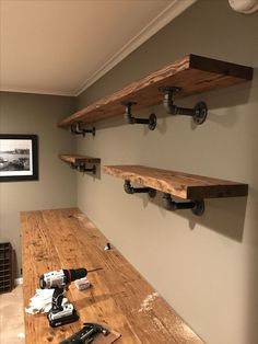 the shelves are made from wood and have pipe fittings on each shelf to hold tools