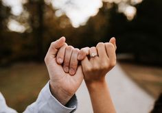 two people holding hands with their fingers together